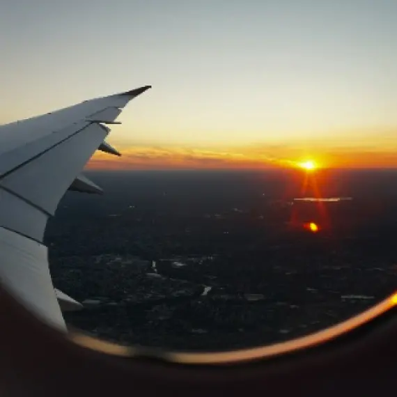 飛行機の窓から見る朝日