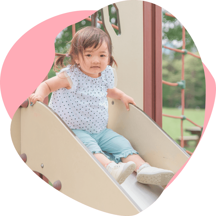滑り台の上からこちらを見る女の子